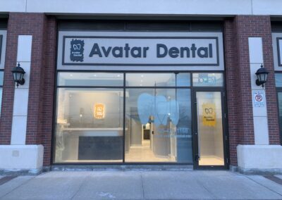 Exterior view of Avatar Dental clinic with illuminated signage, large front windows, and a modern glass entrance